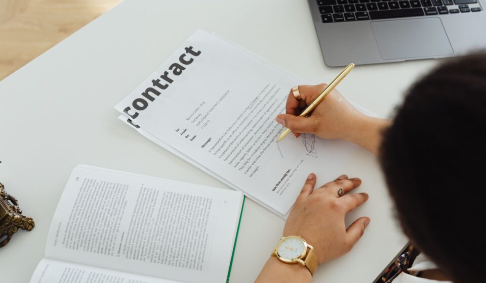 Profissional assinando contrato em uma mesa de escritório