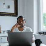 Homem trabalhando no laptop em uma mesa clara
