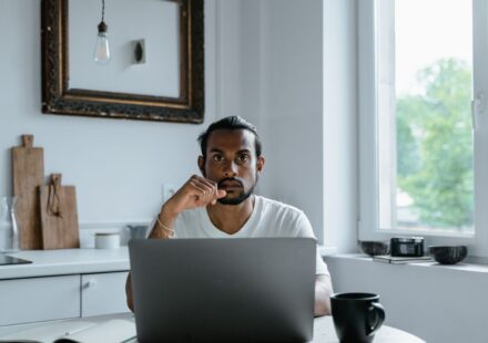 Homem trabalhando no laptop em uma mesa clara