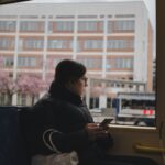 Mulher sentada no ônibus segurando o celular