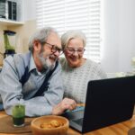 Casal de idosos usando um laptop juntos em casa