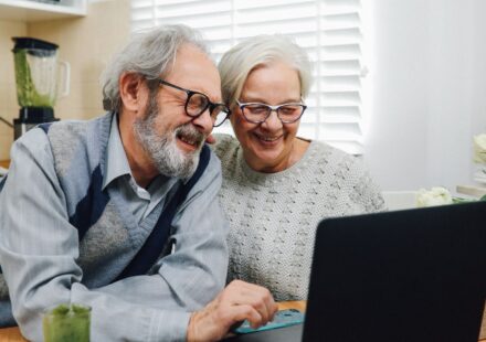Casal de idosos usando um laptop juntos em casa
