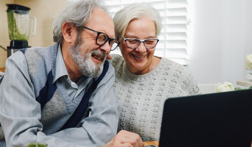 Casal de idosos usando um laptop juntos em casa