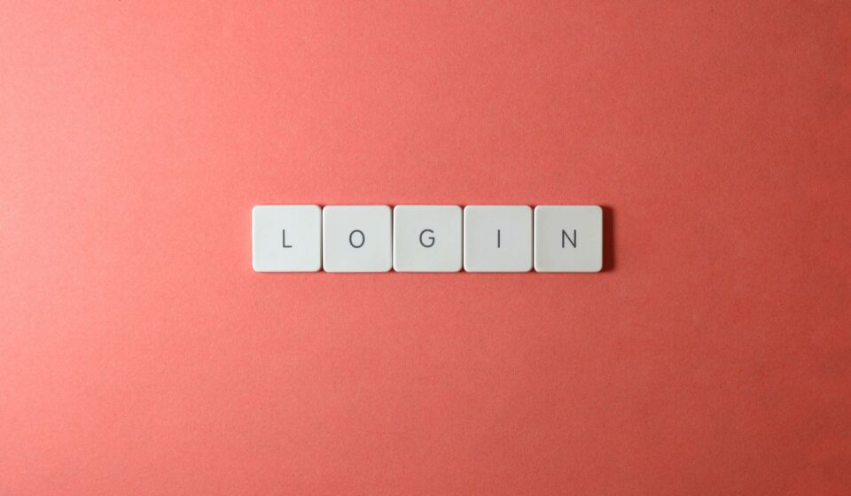 Peças de teclado formando a palavra login sobre fundo coral