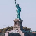 Visto americano: o que conferir no passaporte antes de pedir Estátua da Liberdade sob céu azul em Nova York